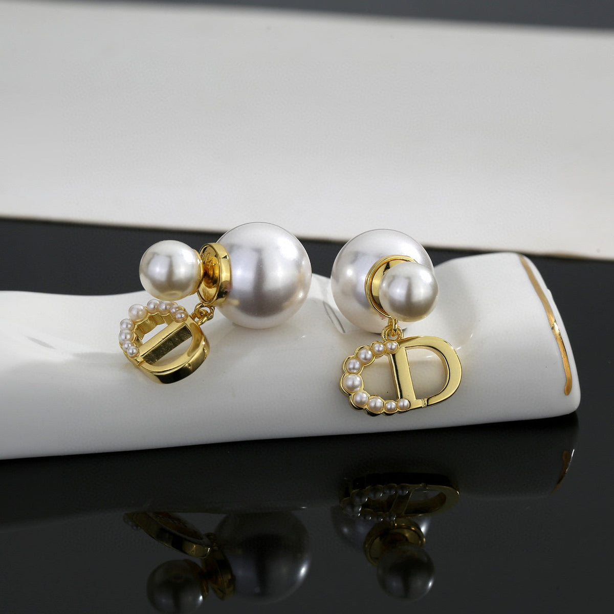 Martin Graham stud earrings in polished metal-tone – close-up detail