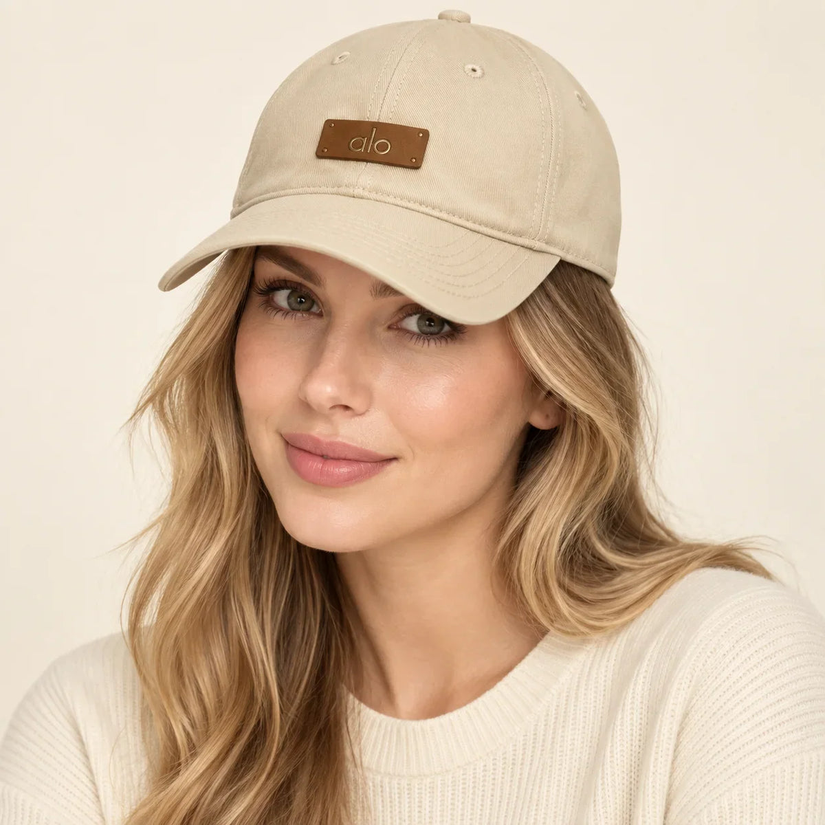 Model wearing metal logo baseball cap on head