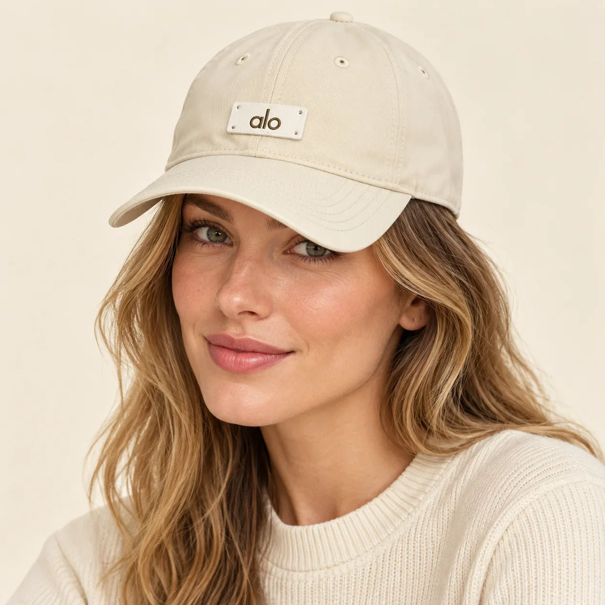 Model wearing metal logo baseball cap on head