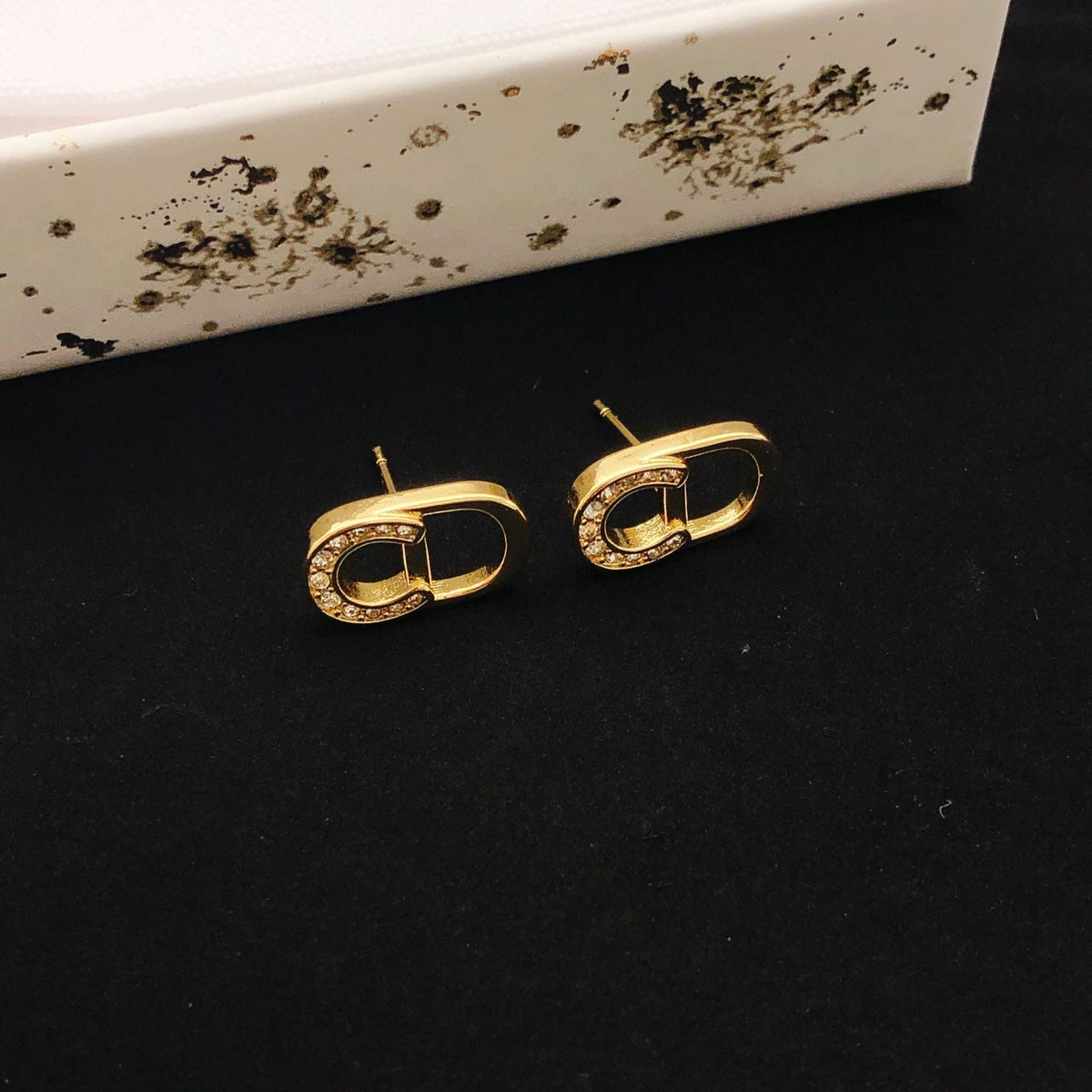 Martin Graham stud earrings in polished metal-tone – detail view