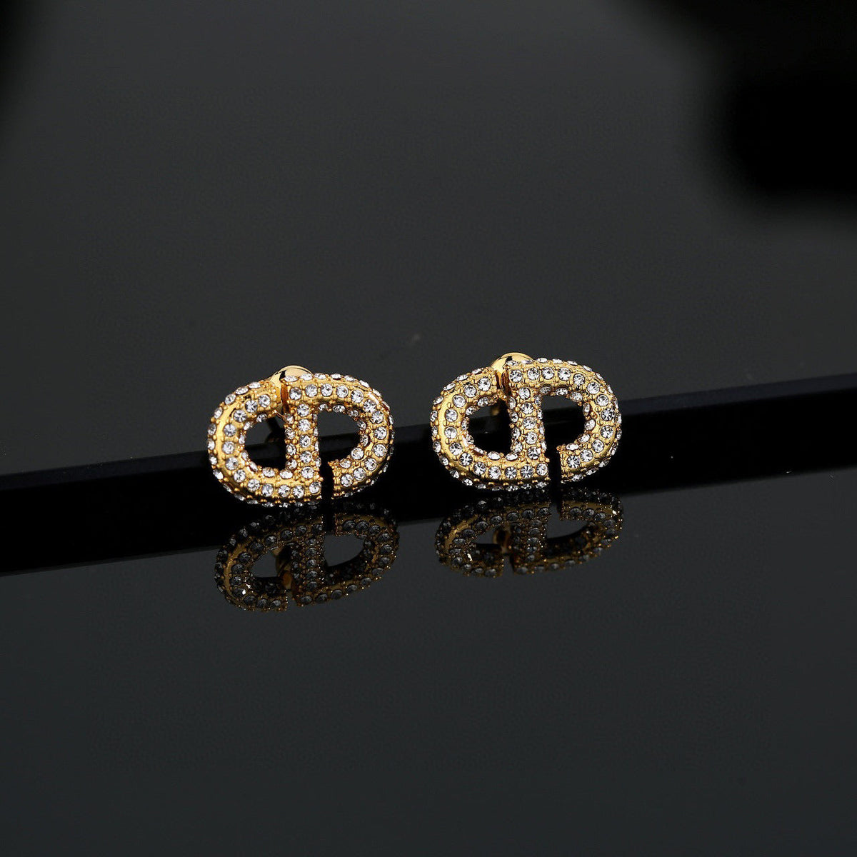 Martin Graham stud earrings in polished metal-tone – close-up detail