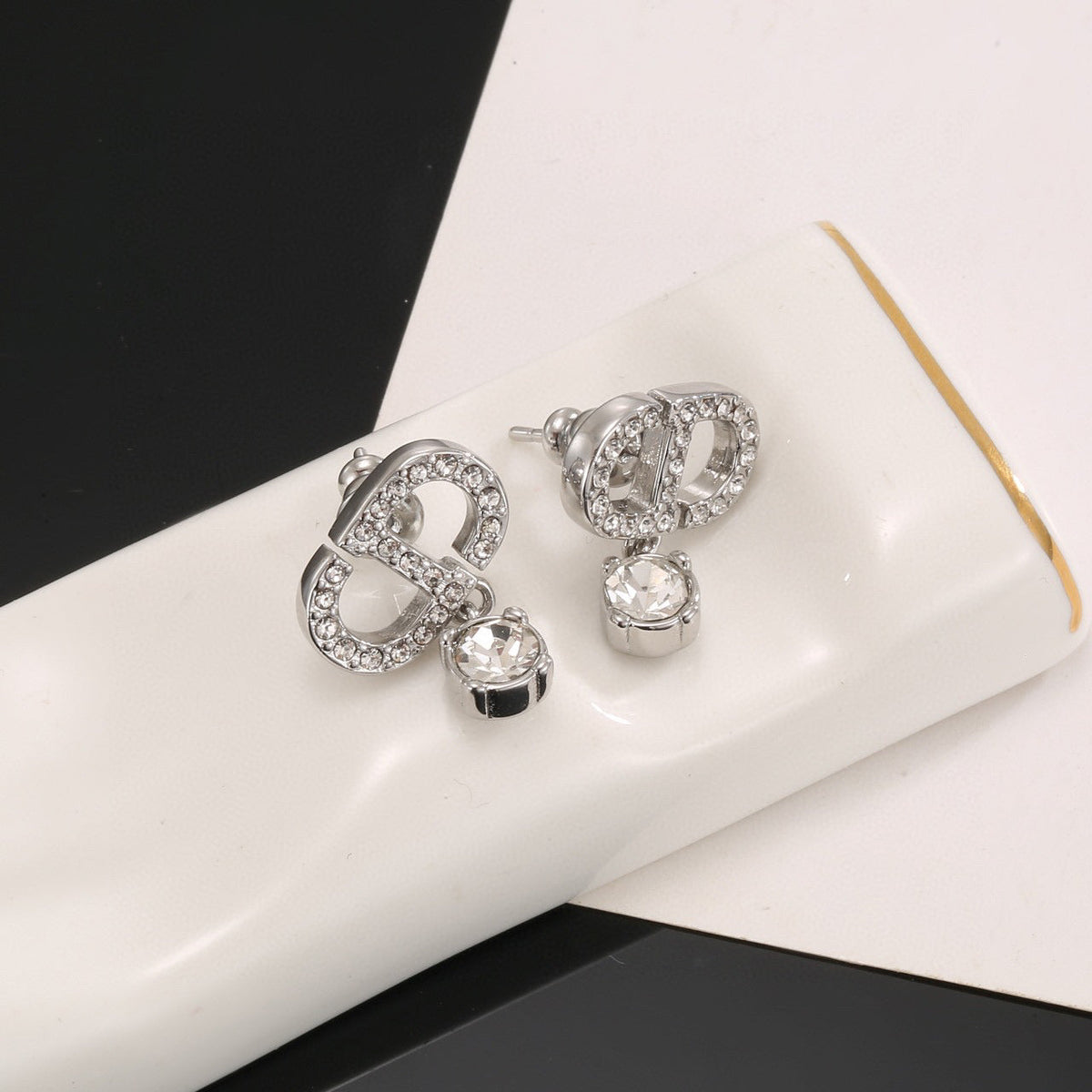 Martin Graham stud earrings in polished metal-tone – close-up detail